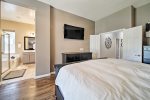 Master bedroom suite w/ king size bed, relaxing area, and Smart TV 